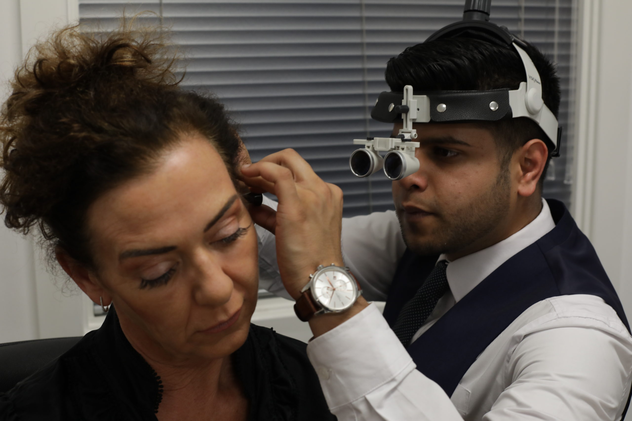 Audiologist at The Hearing Specialist examining a patient’s ear in clinic